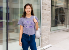 Student standing with a back pack on campus